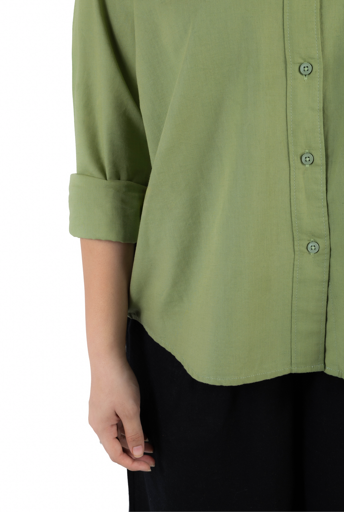 Close-up of a person wearing an olive green button-front shirt with rolled sleeves and black bottoms, photographed against a plain white background.