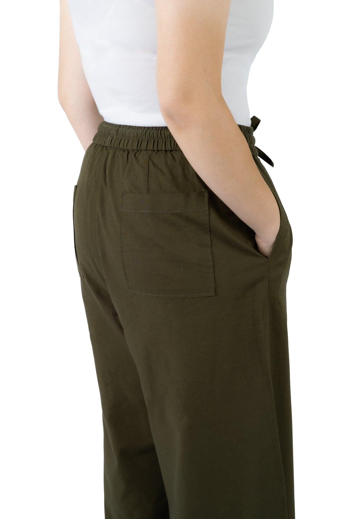 A person wearing olive green drawstring trousers with a side pocket, paired with a white top, shown from the back against a white background.