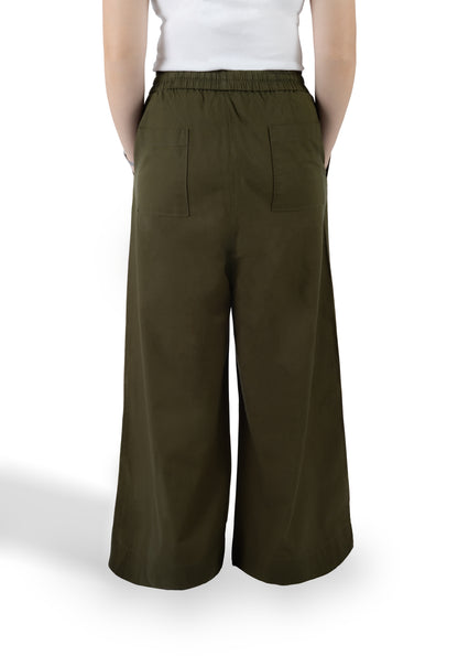 A person shown from the back wearing wide-leg olive green pants with an elastic waistband and two large back patch pockets, paired with a white top against a plain white studio background.