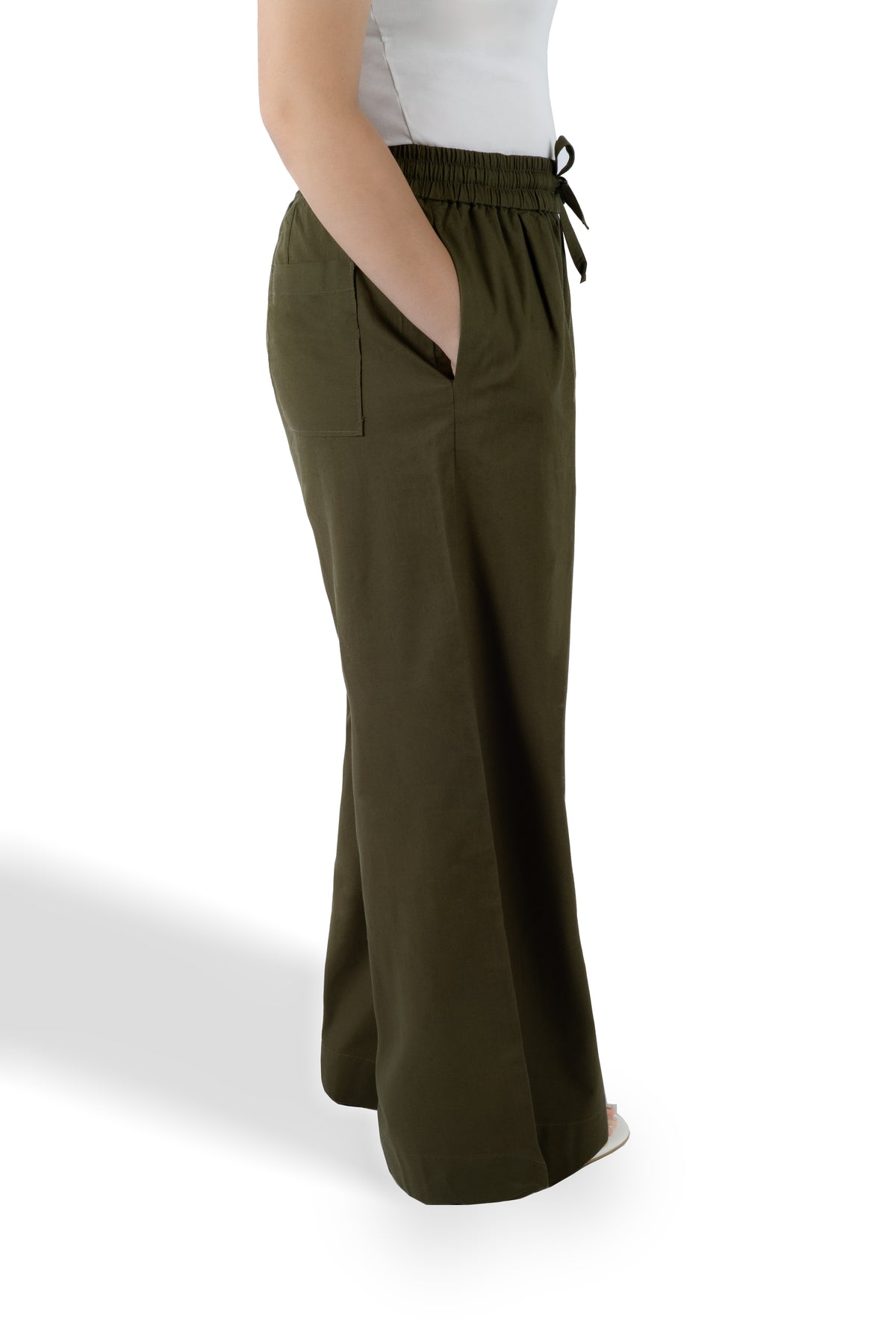 A person wearing olive green wide-leg pants with a drawstring waistband, shown from the waist down against a clean white background.