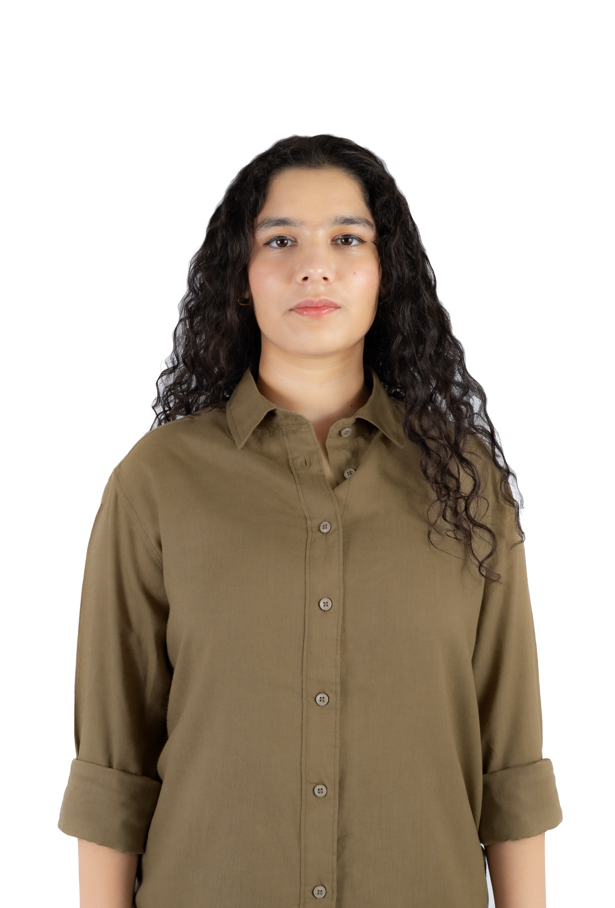 A woman with long, curly dark hair wearing a muted olive-brown button-up shirt with rolled sleeves, photographed against a plain white background.