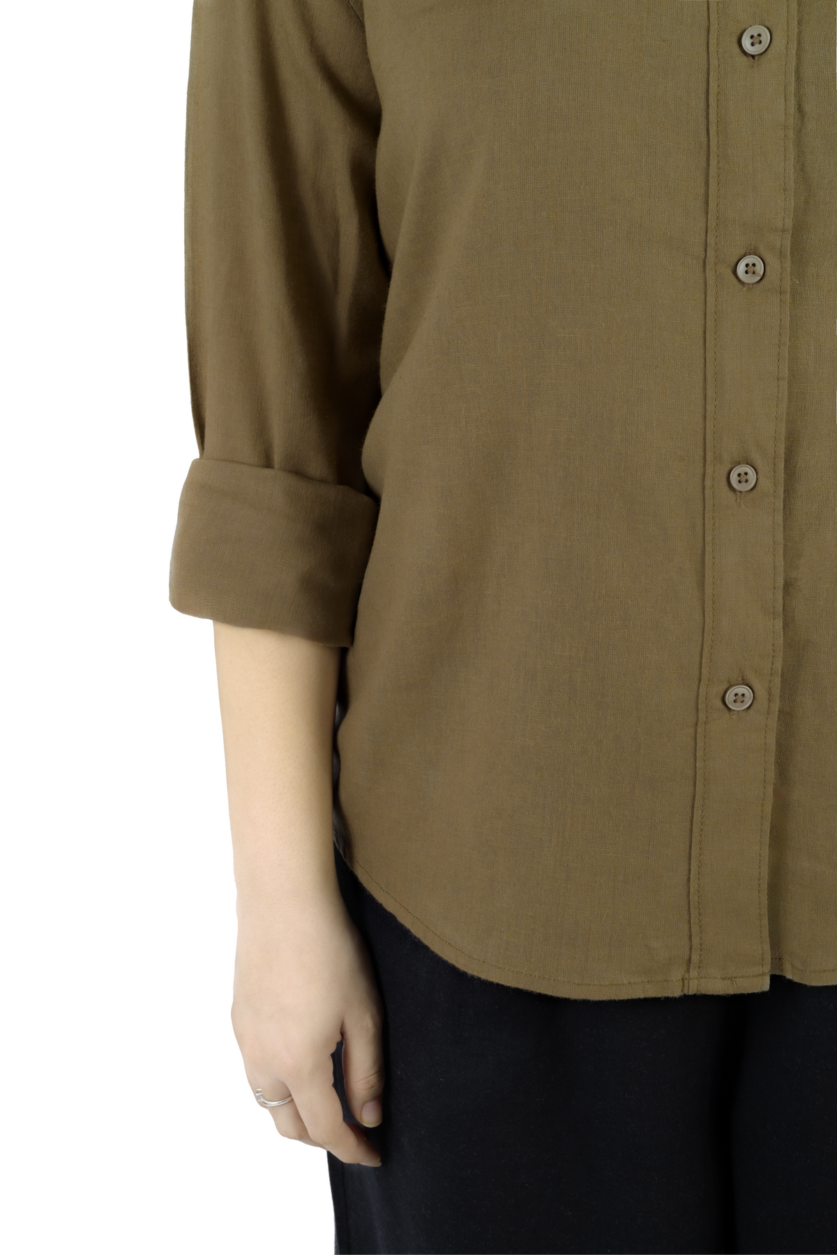 A close-up of a person wearing a muted olive-brown button-up shirt with rolled sleeves and dark pants, photographed against a plain white background.