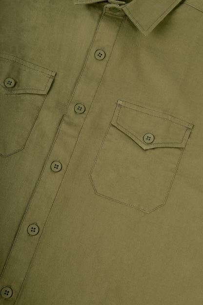 Close-up of an olive green button-down shirt showing the chest pocket, button closure, and collar.