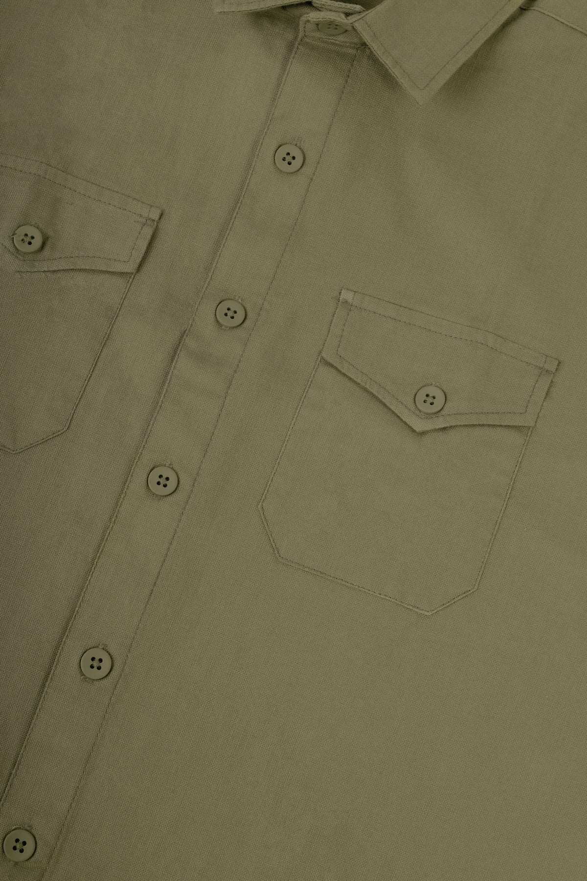 Close-up of a button-front shirt with two chest pockets and a pointed collar in a muted olive-tan color.