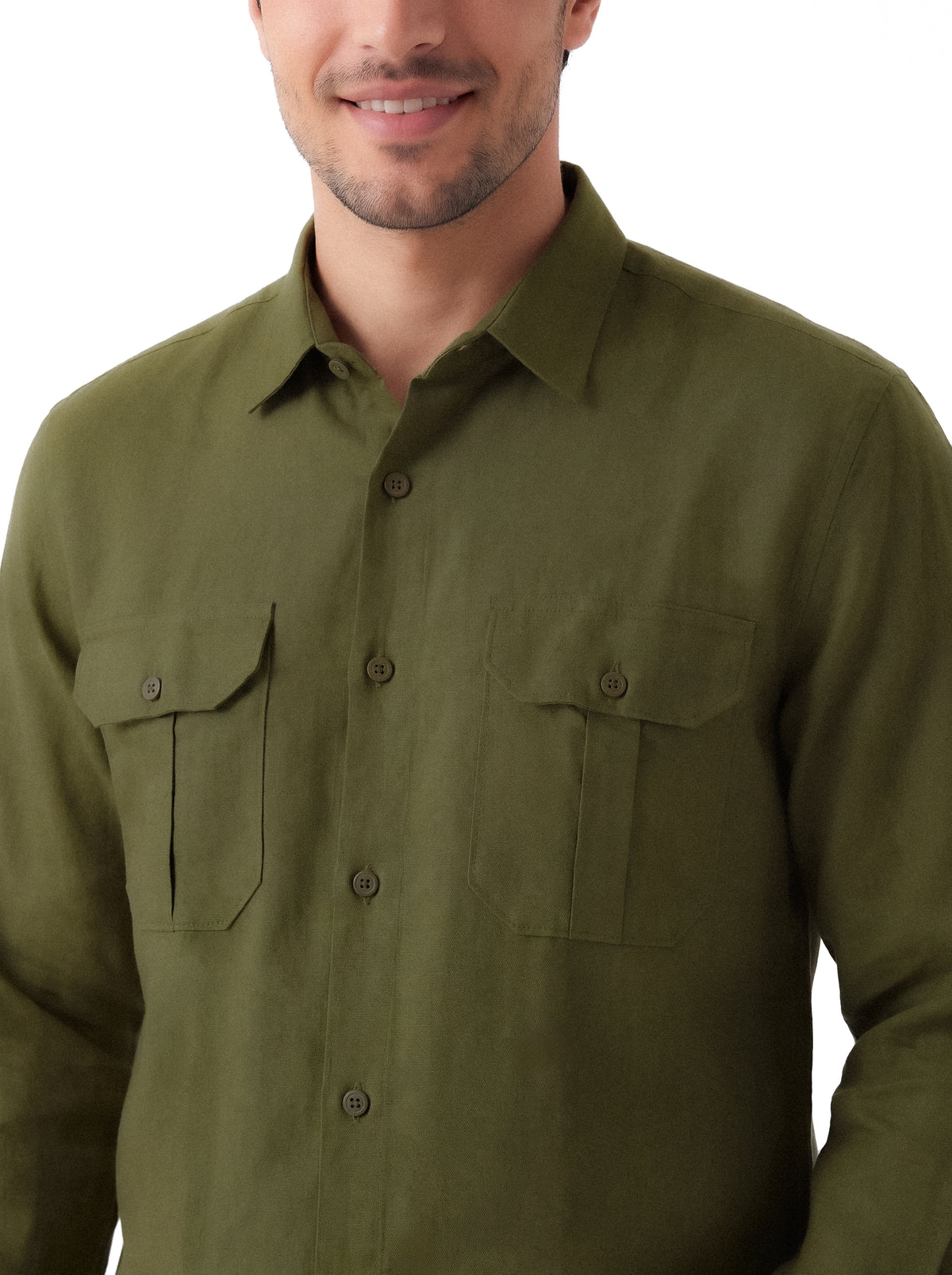 A man wearing an olive green long-sleeve button-up shirt with two buttoned chest pockets, shown from the chin down against a plain white background.