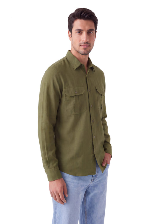 A man wearing an olive green long-sleeve button-up shirt with two chest pockets and light blue jeans, standing against a plain white background.