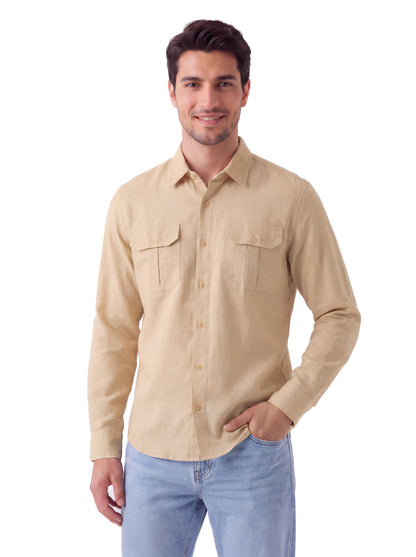 A man wearing a light beige long-sleeve button-up shirt with two chest pockets and light blue jeans, standing against a plain white background.