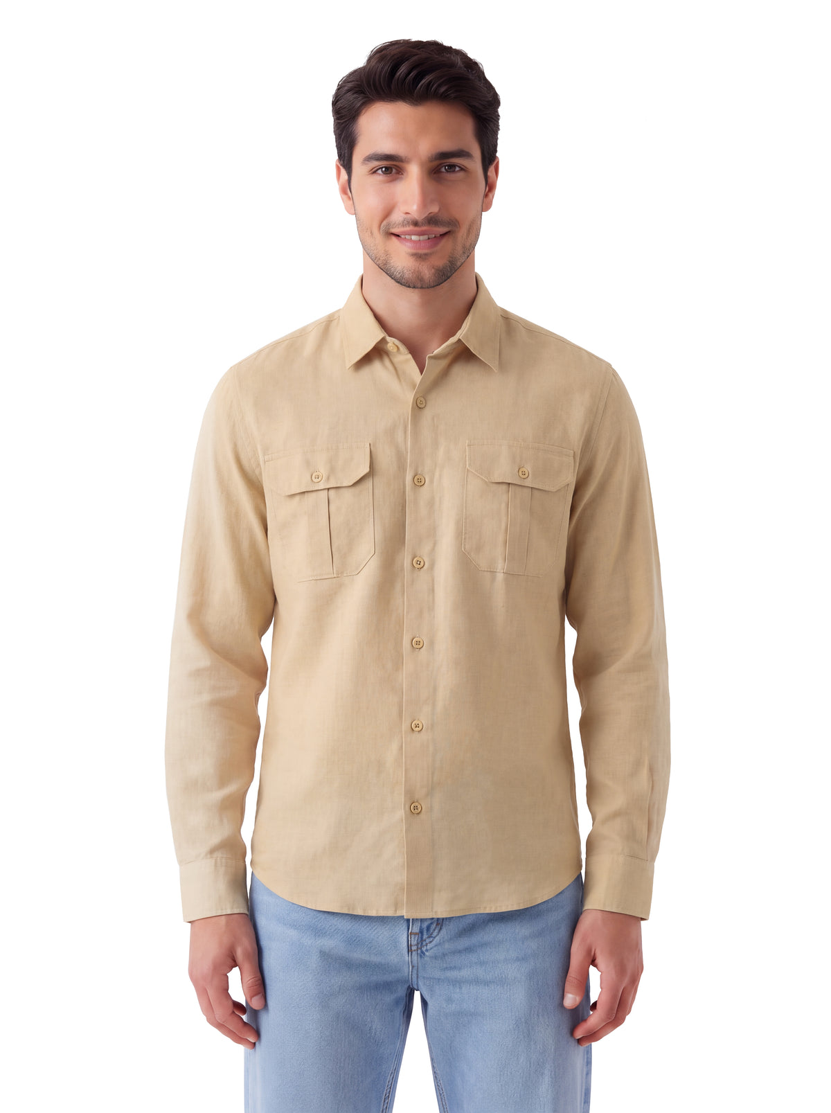 A man wearing a beige long-sleeve button-down shirt with two chest pockets and light blue jeans, standing against a plain white background.