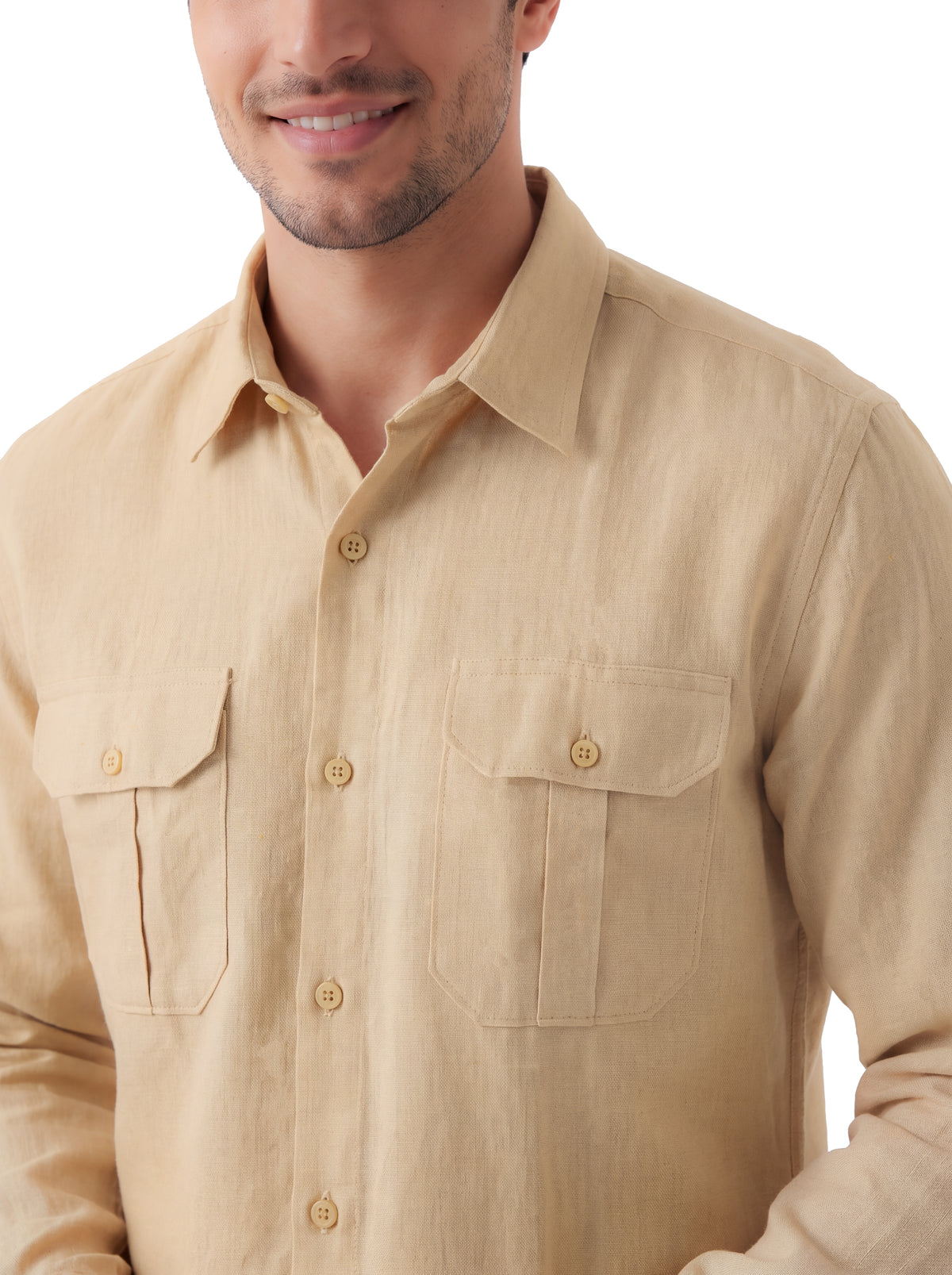 A man wearing a light beige linen button-down shirt with two chest pockets, shown from the chin down against a white background.