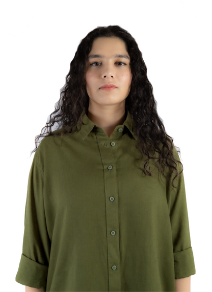 A woman with long, curly dark brown hair wearing an olive green button-down shirt, photographed against a solid white background.