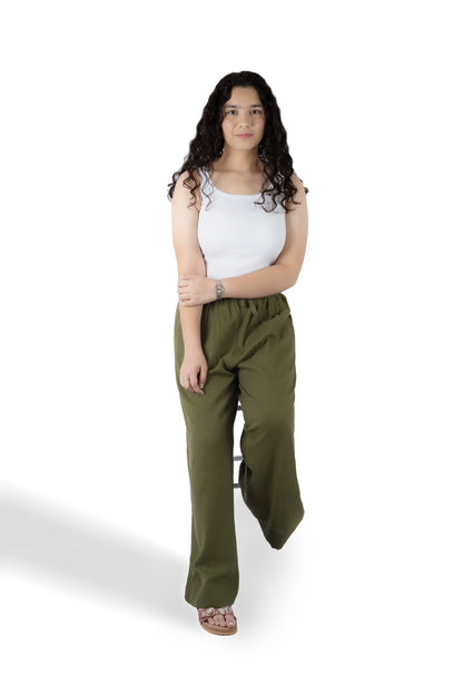 A woman modeling a pair of olive green wide-leg pants with a white sleeveless top, standing against a plain white background.