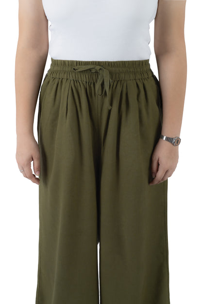 A person wearing olive green wide-leg drawstring pants with an elastic waistband, paired with a white sleeveless top, shown against a plain white background.