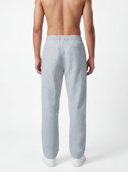 A man shown from the back wearing light gray linen trousers, photographed against a clean white studio background.