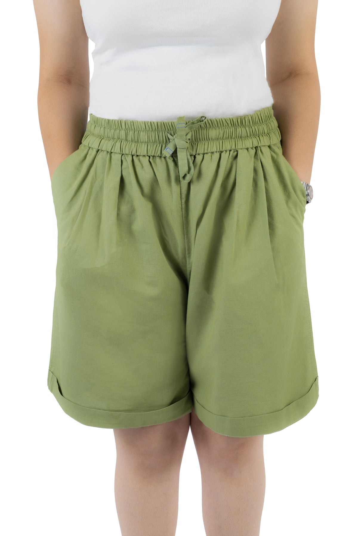 A person wearing olive green drawstring shorts with a white sleeveless top, shown from the chest to the knees against a plain white background.