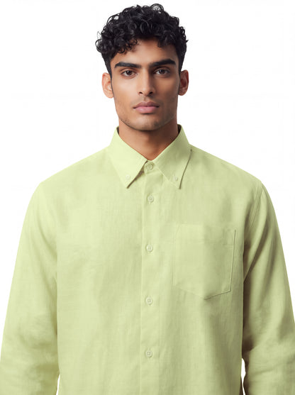 A man wearing a light yellow-green long-sleeve button-down shirt with a chest pocket, photographed against a plain white background.