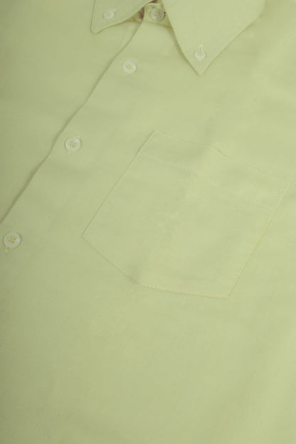 A close-up of a pale yellow-green button-down shirt showing the collar, front buttons, and a chest pocket.