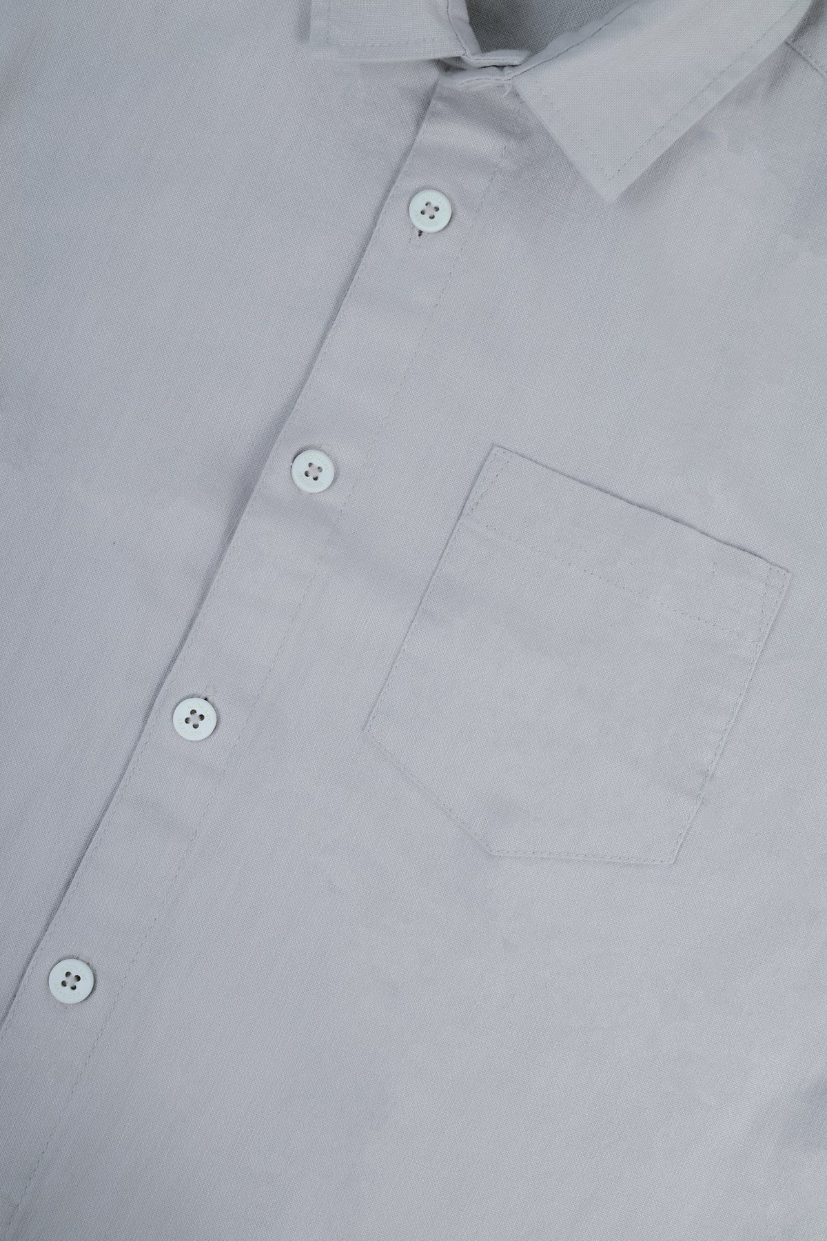 Close-up of a light gray button-down shirt showing the collar, front buttons, and chest pocket.