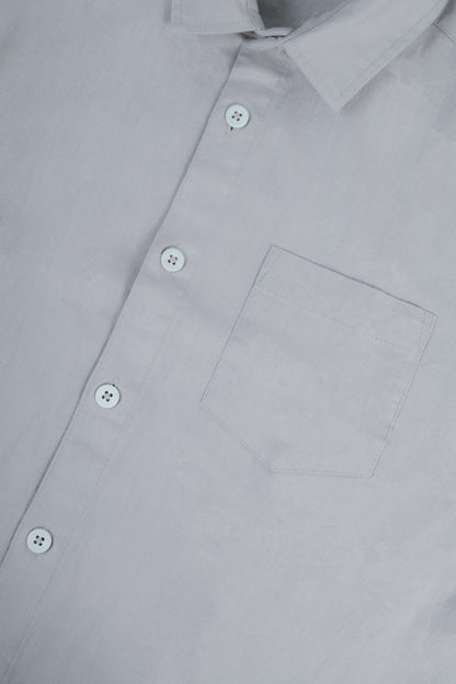 Close-up of a light gray button-down shirt showing the collar, front buttons, and chest pocket.