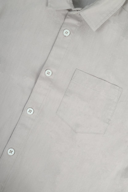 Close-up of a light gray button-down shirt showing the collar, front buttons, and chest pocket.