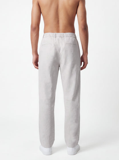 A man shown from the back wearing light gray linen trousers, photographed against a clean white studio background.